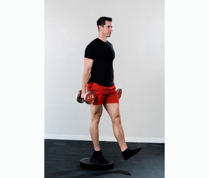 Caucasian man in black T-shirt and red shorts doing Poliquin stepup